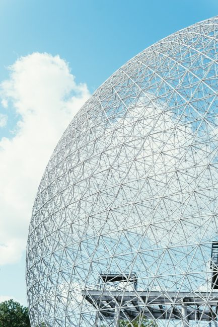 Vertical shot of a globe-shaped construction under the bright cloudy sky